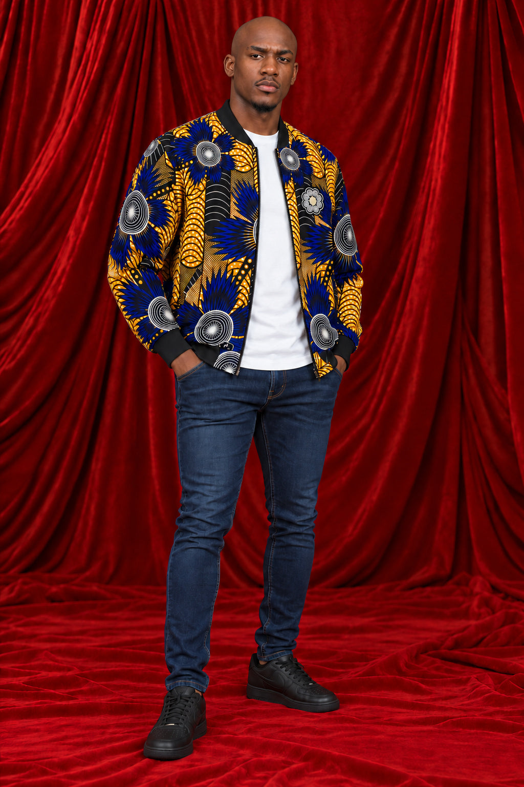 Full-length view of the Chepa Sizwe Print Bomber Jacket in blue and gold with blue jeans