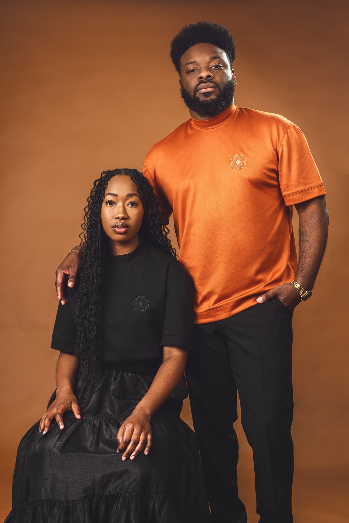 A man in the burnt orange Lush Tee and a woman in the black Lush Tee